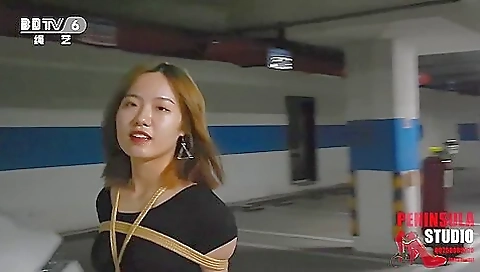 Young Chinese Girl Walks Around Carpark Tied Up